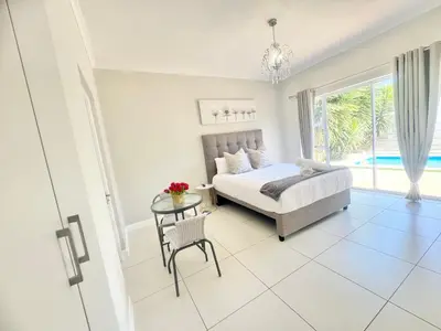 a bedroom with a bed and a table at Villa Sunn in Cape Town
