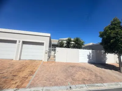 a house with white garage doors and a brick driveway at Villa Sunn in Cape Town