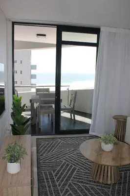 a living room with a view of the ocean at Luxurious 3-bedroom Bloubergstrand Cape Town beachfront apartment with stunning sea and beach view in Cape Town