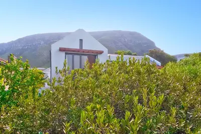 a house with a cross on the side of a hill at On Golf Estate Sea & Mountain Views Design Winner in Hermanus