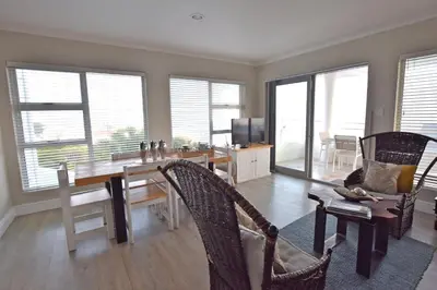 a living room with a dining room table and chairs at Apartment Dolphin House in Hermanus