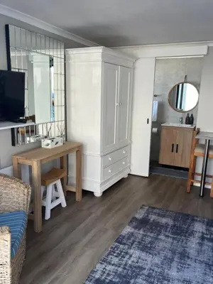 a living room with a desk and a cabinet at Apartment Dolphin House in Hermanus