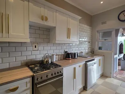a kitchen with white cabinets and a stove top oven at Franschhoek Farm Cottages in Franschhoek