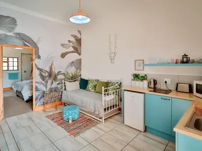 a kitchen and a living room with a couch at Franschhoek Farm Cottages in Franschhoek