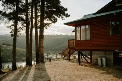 a cabin with a view of a river and trees at Elgin River Lodge in Elgin