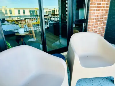 two white chairs sitting on top of a balcony at Cape Town Studio for business travel in Cape Town