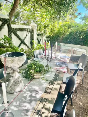 a table with chairs and a laptop on it at Garden Hideaway in Stellenbosch