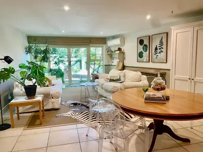 a living room with a table and a couch at Garden Hideaway in Stellenbosch