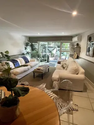 a living room with couches and a table at Garden Hideaway in Stellenbosch