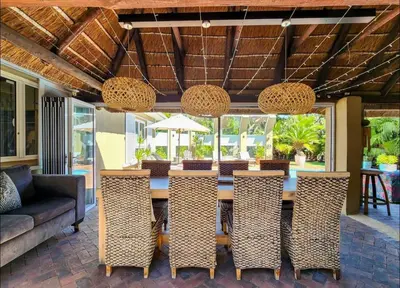 a dining room with a table and chairs at Sunset Bliss Villa, Sunset Beach, Cape Town in Cape Town