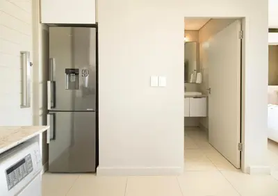 a kitchen with a stainless steel refrigerator at Sonvanger Studio at Andringa Mall Luxury Apartments in Stellenbosch
