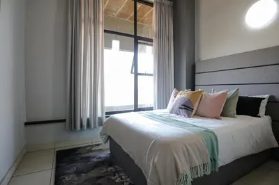 a bedroom with a bed with a large window at VIXIRITE APARTMENTS & HOTELs in Cape Town