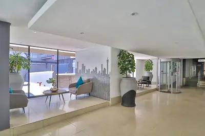 a lobby with chairs and potted plants in a building at VIXIRITE APARTMENTS & HOTELs in Cape Town
