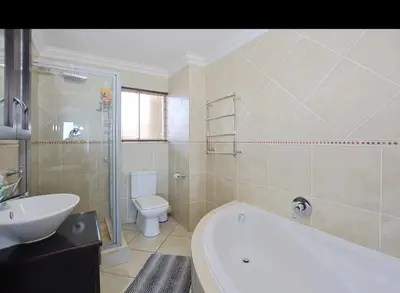 a bathroom with a tub and a toilet and a sink at VIXIRITE APARTMENTS & HOTELs in Cape Town