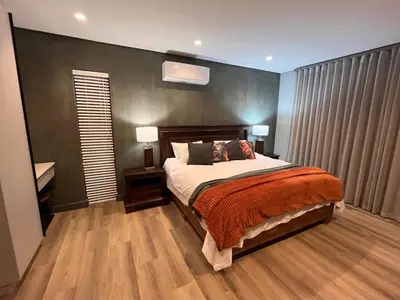 a bedroom with a large bed and two lamps at 18 On Louvre Guesthouse in Paarl