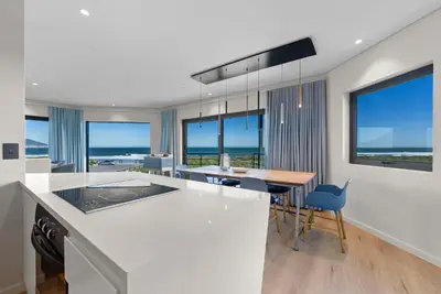 a kitchen and dining room with a table and chairs at ocean12 Guesthouse Sunset Beach in Cape Town