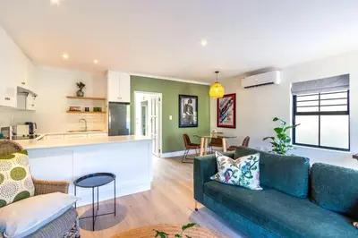 a living room with a couch and a kitchen at Tram Vibes in Franschhoek