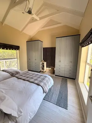 a bedroom with a large bed with white cabinets at Charming Country Escape with Mountain Views in Hermanus