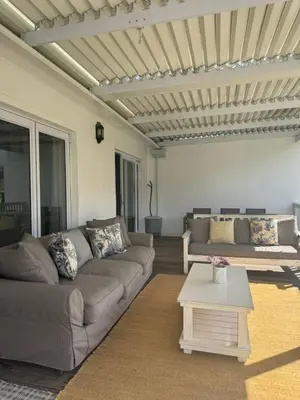 a living room with a couch and a table at Charming Country Escape with Mountain Views in Hermanus
