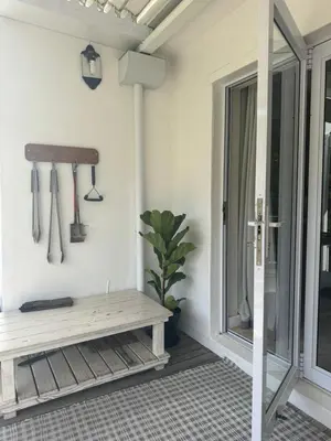 a porch with a bench and a potted plant at Charming Country Escape with Mountain Views in Hermanus