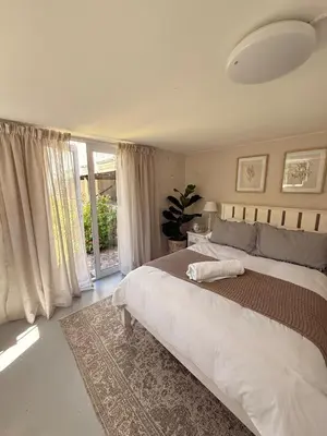 a bedroom with a large bed and a large window at Charming Country Escape with Mountain Views in Hermanus
