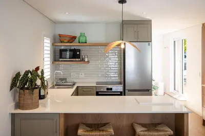 a kitchen with a white counter top and a kitchen island at One on Main in Franschhoek