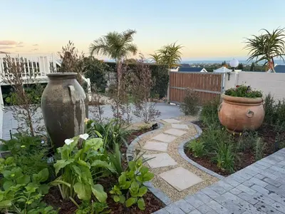 a garden with a stone path and a large vase at Yellow Wood 1 in Hermanus