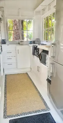 a kitchen with white cabinets and a rug on the floor at Oh so Heavenly in Cape Town