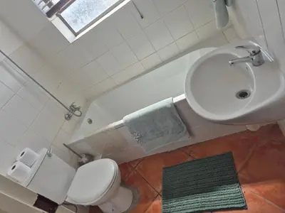 a bathroom with a white toilet and a sink at Remmys Flat in Goodwood