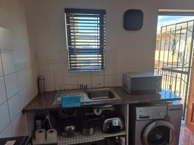 a small kitchen with a sink and a microwave at Remmys Flat in Goodwood