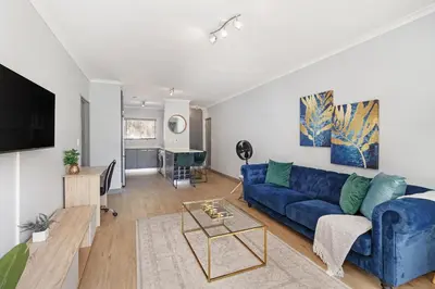a living room with a blue couch and a table at Dorphene 204 in Cape Town