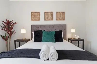 a bedroom with a white bed with two night stands at Dorphene 204 in Cape Town