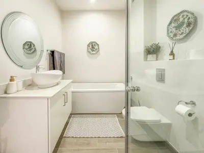 a white bathroom with a sink and a mirror at Tre Jolie in Franschhoek