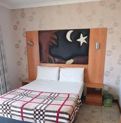a bedroom with a bed with a wooden headboard at Lookout Star Legend Accommodation in Parow