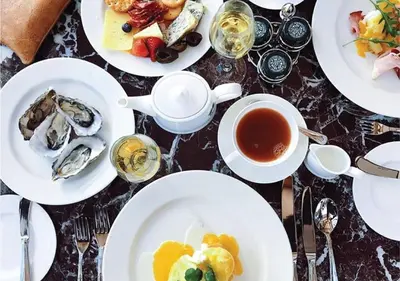 a table with plates of food and a cup of tea at Lanzerac Hotel & Spa in Stellenbosch