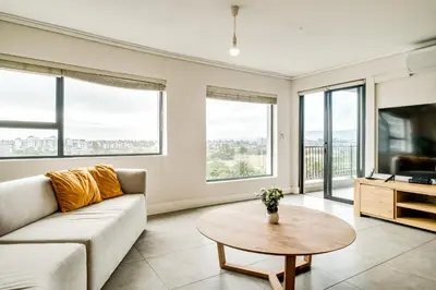 a living room with a couch and a table at Belina - Waters Edge Premier in Cape Town