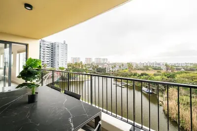 a balcony with a table and a view of a city at Belina - Waters Edge Premier in Cape Town