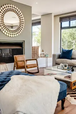a living room with a couch and a mirror at Belina - Sunset Links Golf Course Villa in Cape Town