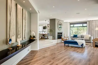 a living room with a blue couch and a living room at Belina - Sunset Links Golf Course Villa in Cape Town