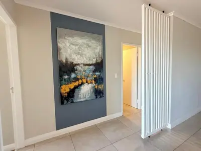 a hallway with a painting on the wall at Elegant Two Bedroom Apartment in Century City in Cape Town