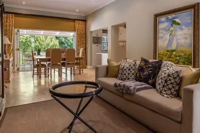a living room with a couch and a table at La Petite Maison in Franschhoek