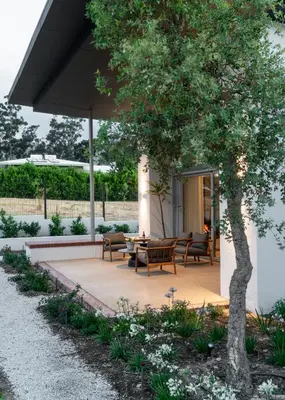 a patio with a table and chairs and a tree at 6 on Heide in Franschhoek