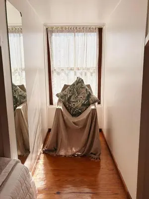 a bedroom with a bed and a window at Nimara de So in Gordonʼs Bay