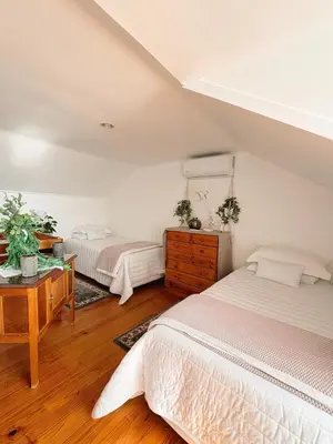 a bedroom with two beds and a desk with a desk at Nimara de So in Gordonʼs Bay