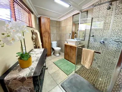 a bathroom with a shower and a toilet and a sink at Modern Van Riebeeck Park Accomodation in Worcester