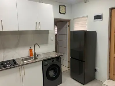 a kitchen with a refrigerator and a washing machine at GRACE self-catering apartments in Goodwood
