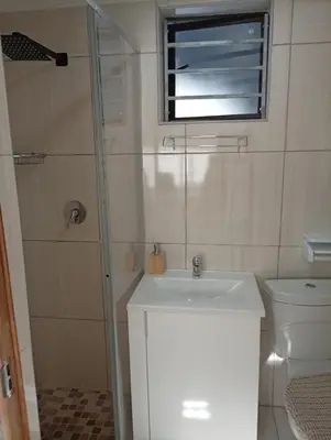 a bathroom with a sink and a toilet and a window at GRACE self-catering apartments in Goodwood