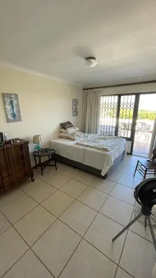a bedroom with a bed and a large window at Kleine Villa mit Pool und freie Sicht auf die Berge in Somerset West
