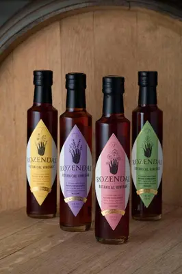 a group of four bottles of hot sauce on a shelf at Rozendal Stay in Stellenbosch