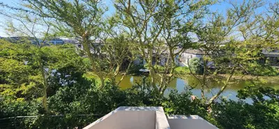 a view of a river with trees and a boat at Water side Town house on the canal in Cape Town